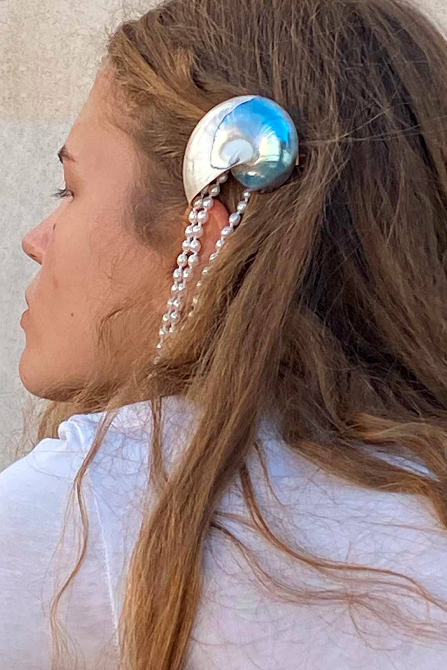 Side view of nautilus shell hair clip showcasing 18k gold-plated silver barrette and natural shell texture