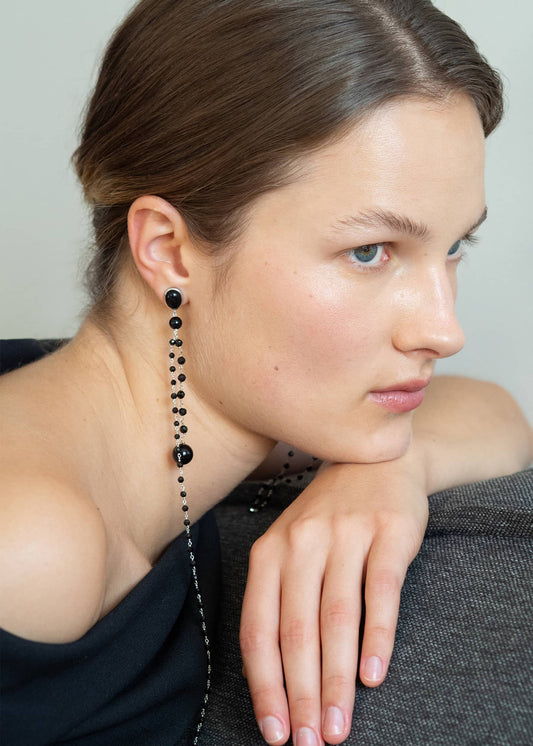 Sculptural onyx earrings with sterling silver chains, designed to be worn extended or folded for two distinctive shapes.