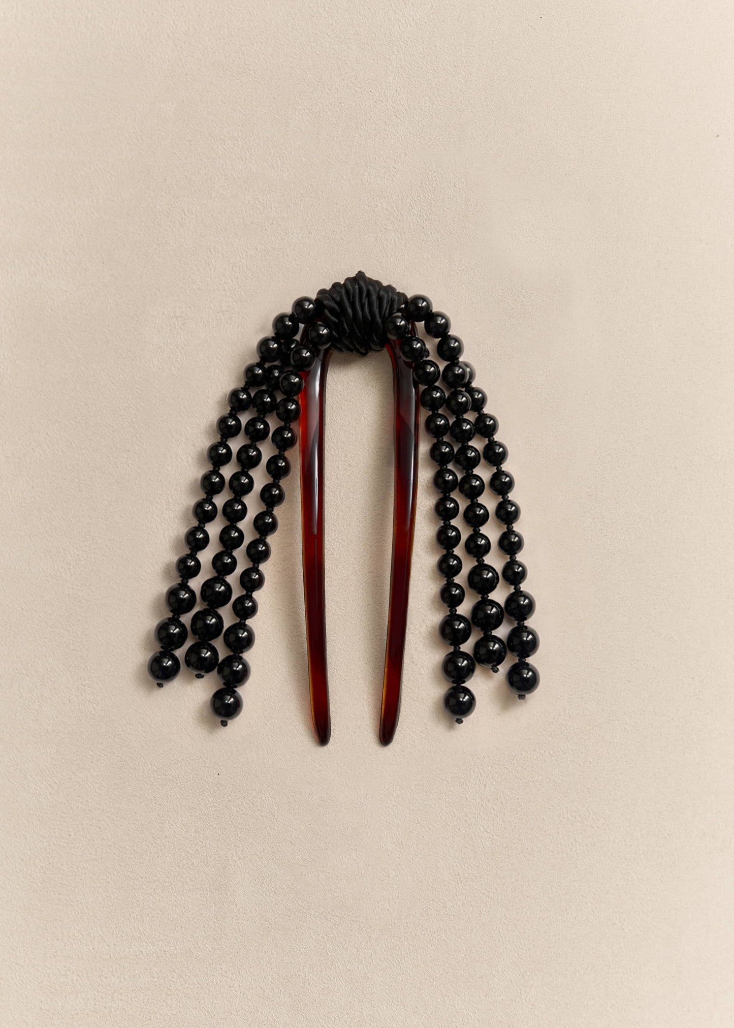 A sculptural hair comb handcrafted with onyx beads and sterling silver details. An everyday object elevated through craftsmanship.