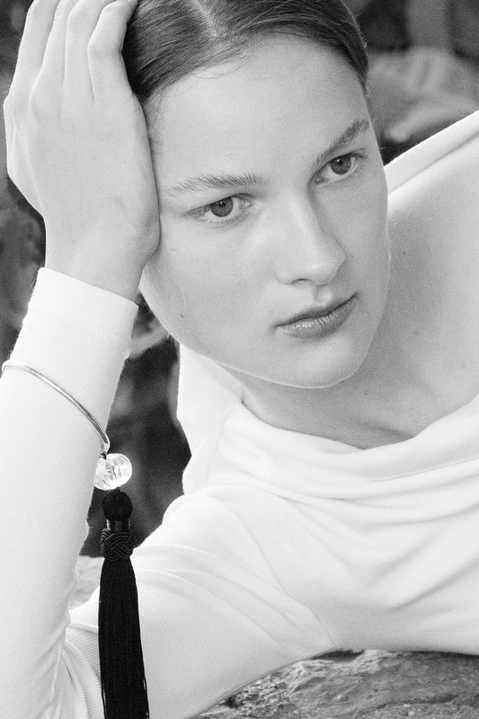 Model wearing the Lacanau bracelet crafted with sterling silver, crystal quartz bead and silk tassel.