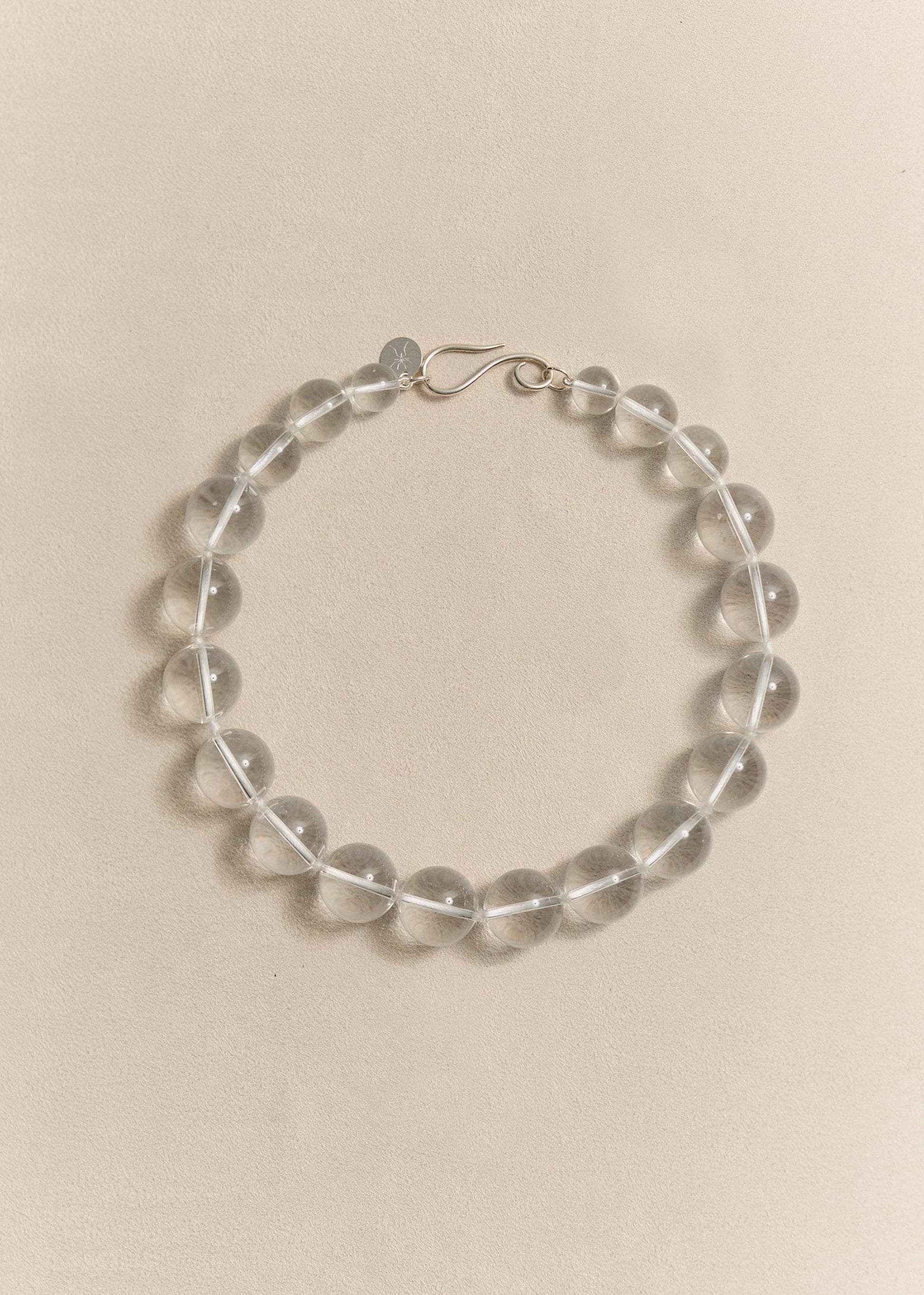 A handcrafted sterling silver necklace featuring natural rock crystal. Sculptural simplicity shaped by traditional craftsmanship.