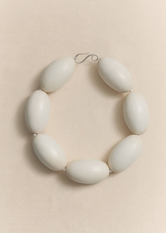 A handcrafted necklace made from natural yakal wood and sterling silver. A quietly sculptural piece created in small batches using traditional techniques.