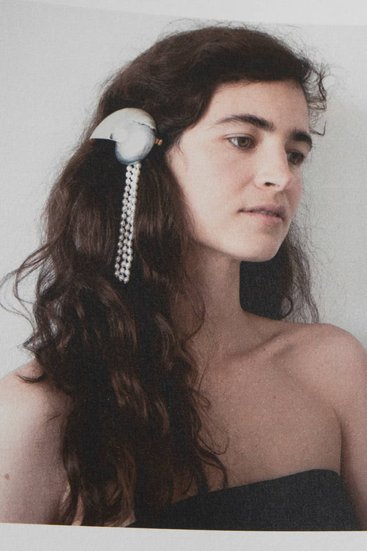 Close-up detail of vintage nautilus shell adorned with lustrous Italian pearls, luxury hair accessory