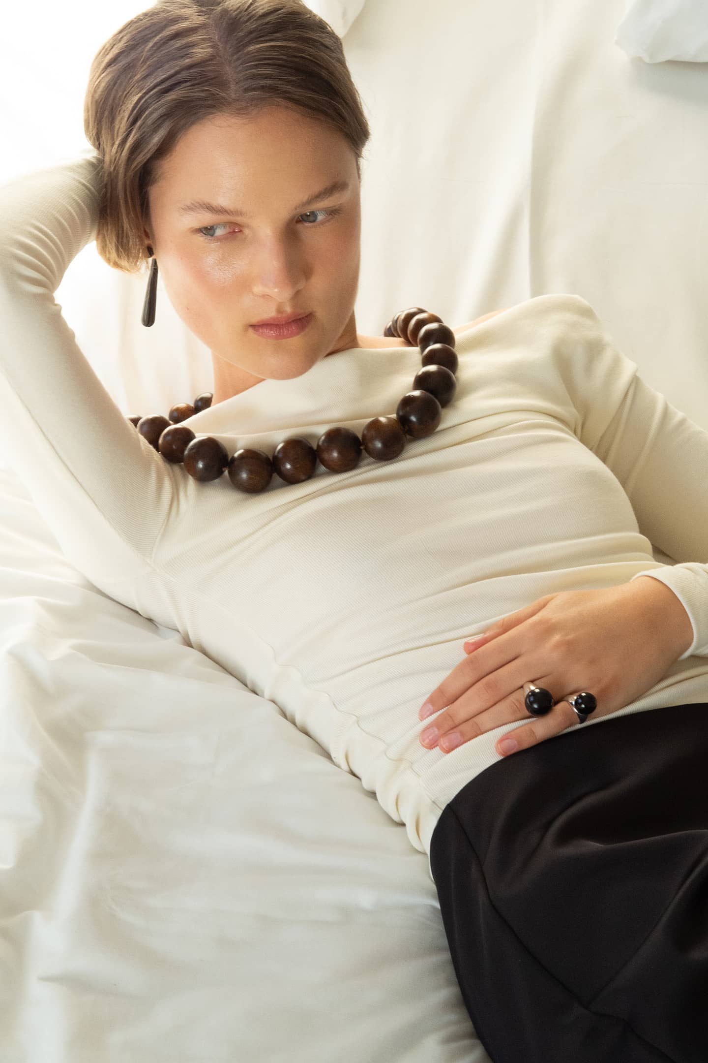 Model wearing the Positano necklace made with handcrafted oak wooden beads.