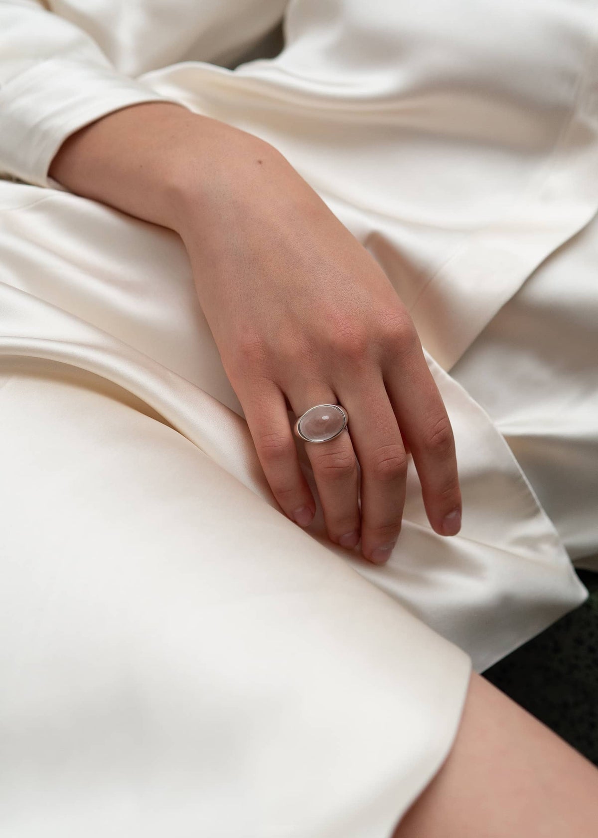 Sculptural statement ring combining a rock crystal gemstone with rhodium-plated sterling silver in a bold modernist design.